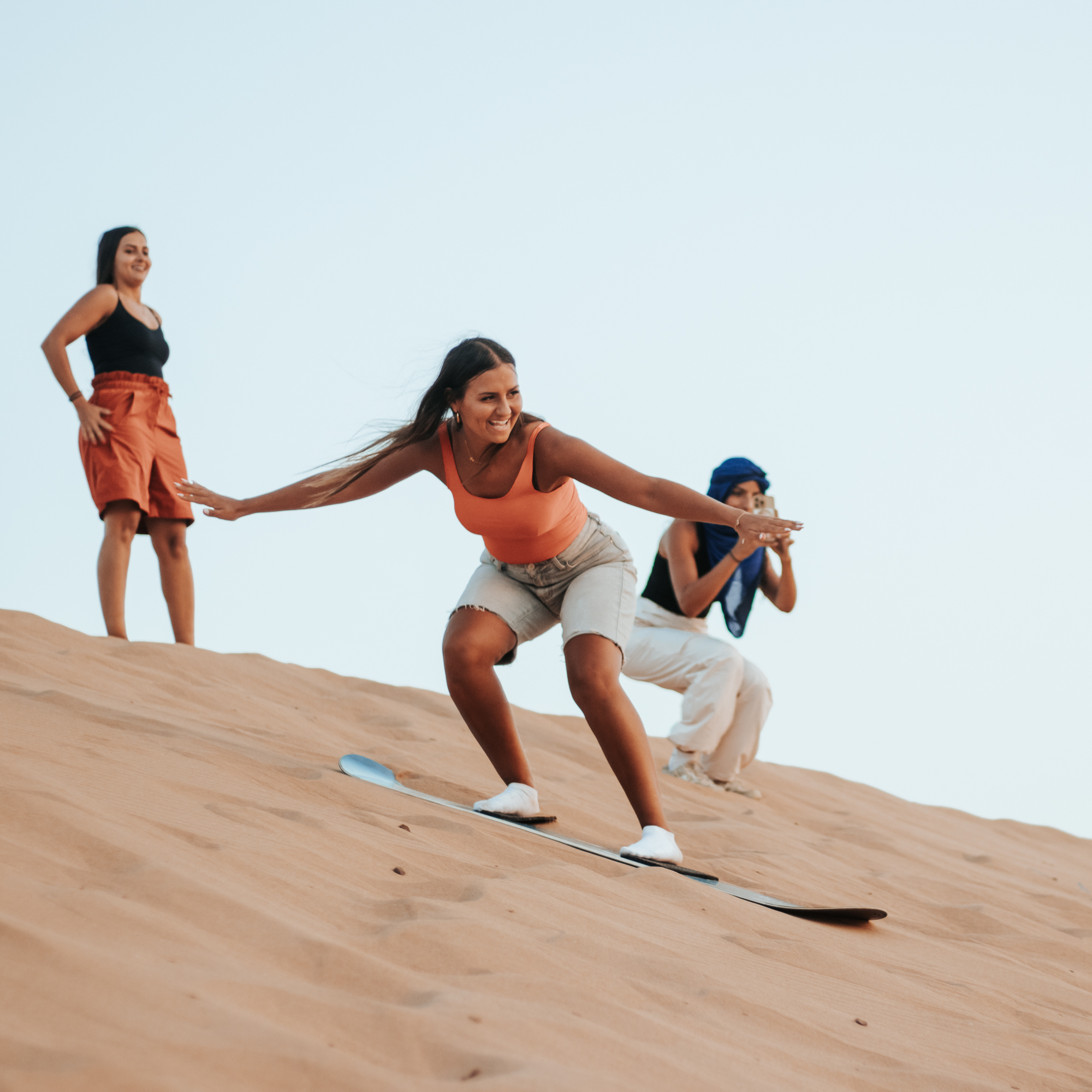 Tourist sandboarding down the Timlalin desert dunes near Agadir Morocco