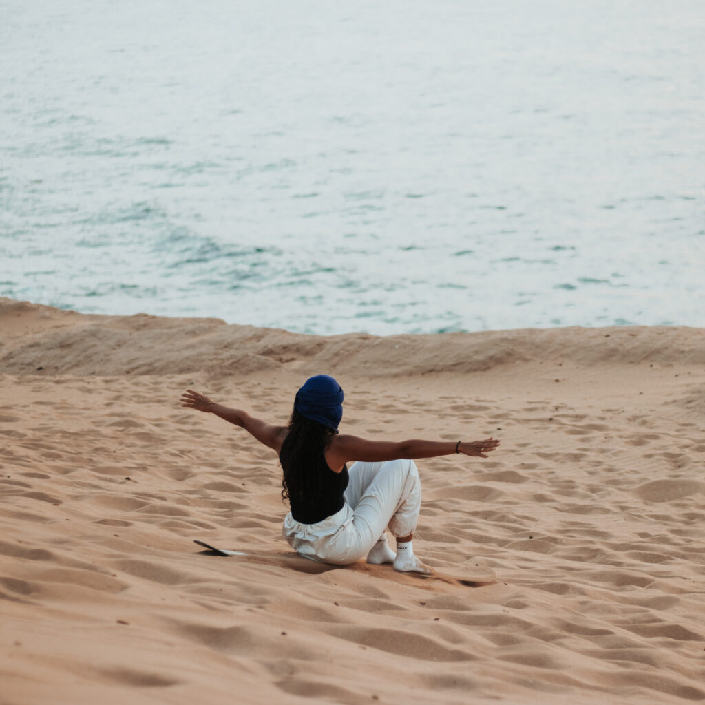 Tourist sandboarding down the Timlalin desert dunes near Agadir Morocco